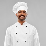 happy male indian chef in toque