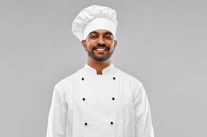 happy male indian chef in toque
